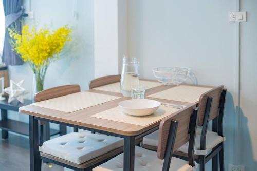 a wooden table with chairs and a bowl on it at THE BEACH CHA AM Suites in Cha Am