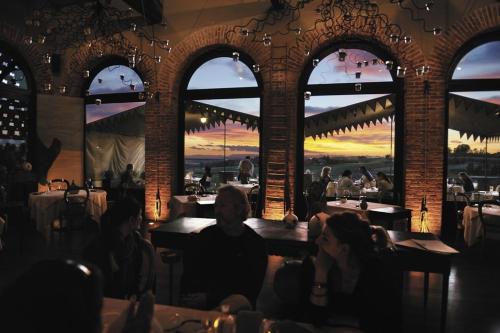 a group of people sitting at tables in a restaurant at Albergo l'Ostelliere - Villa Sparina Resort in Gavi