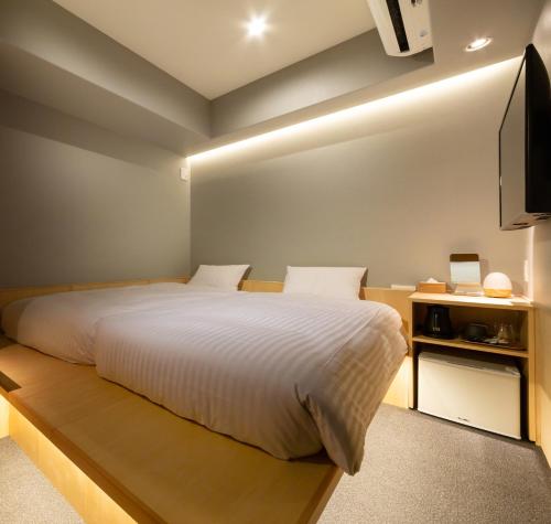 a bedroom with a large bed and a television at HOTEL AMANEK Kyoto Kawaramachi Gojo in Kyoto