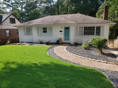 a small white house with a grass yard at Relaxing, Comfortable, Private Bedroom in Atlanta
