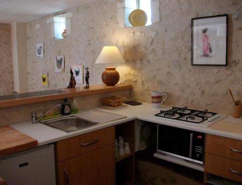 cocina con fregadero y fogones horno superior en La Clé des Chants en Tauxigny