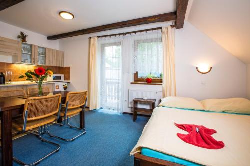 a bedroom with a bed and a table and a kitchen at Apartment Nedrik in Rokytnice nad Jizerou