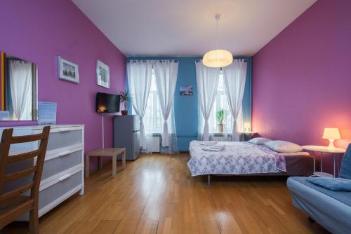 ein Schlafzimmer mit lila Wänden und einem Bett und einem Sofa in der Unterkunft Итальянские комнаты Пио на канале Грибоедова 35 in Sankt Petersburg
