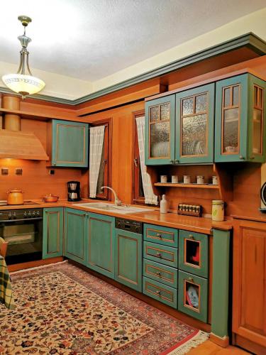 a kitchen with green cabinets and a sink at Villa Ευορέων in Pertouli