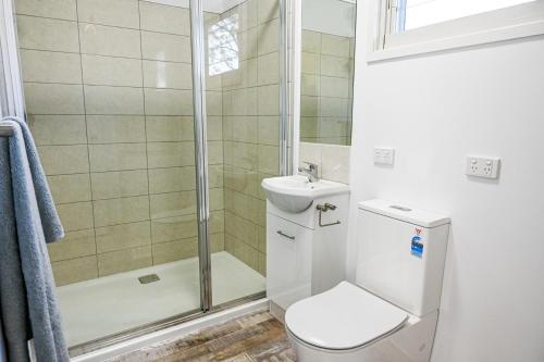 a bathroom with a shower and a toilet and a sink at Kiambram Country Cottages in Gowrie Little Plain