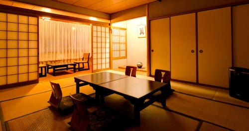 a room with a table and chairs and a dining room at Nara Hakushikaso in Nara