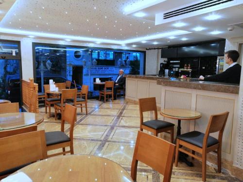 MORAVA HOTEL في إسطنبول: مطعم بطاولات وكراسي وبار
