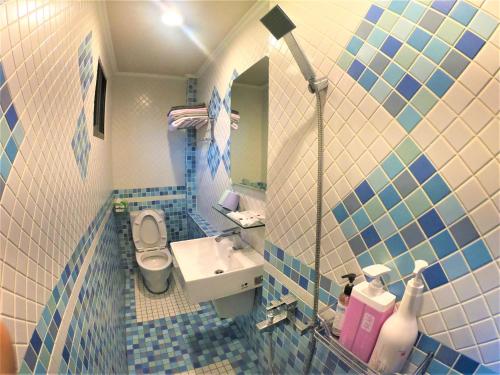 a blue and white bathroom with a sink and a toilet at Islander B&B in Xiaoliuqiu