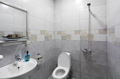 a bathroom with a toilet and a sink at Guesthouse and Cottage Nicolo in Stepantsminda