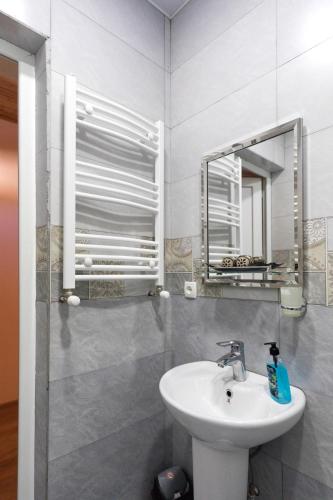 a bathroom with a sink and a mirror at Guesthouse and Cottage Nicolo in Stepantsminda