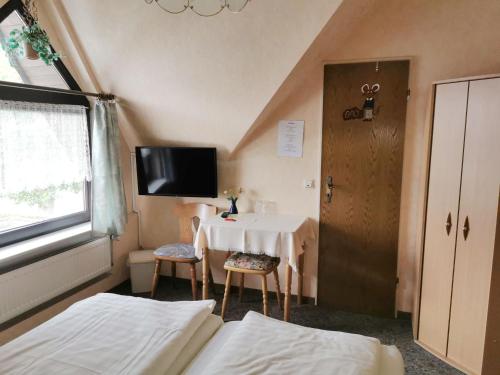 a room with two beds and a table and a tv at Elisabeth Stube in Neuss