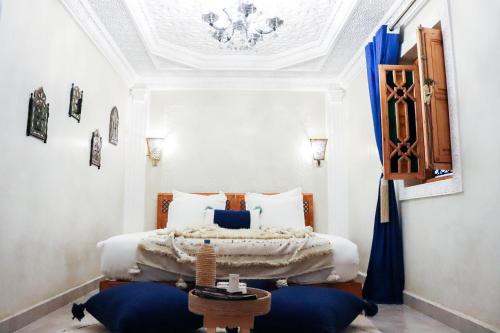 Riad azra Marrakech في مراكش: غرفة نوم مع سرير مزدوج كبير مع الوسائد الزرقاء