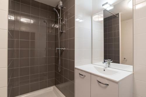 La salle de bains est pourvue d'une douche, d'un lavabo et d'un miroir. dans l'établissement Student Factory Strasbourg Etoile, à Strasbourg
