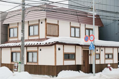 a house with snow on the roof at Lampstand STAY Sapporo-House A in Sapporo