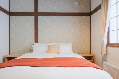 a bedroom with a large bed with a large window at Lampstand STAY Sapporo-House A in Sapporo
