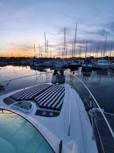 two people sitting on a boat in a marina at Y-Knot-Two Bedroom Luxury Motor Boat In Lymington in Lymington