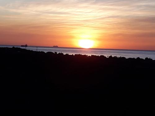 a sunset on the beach with the sun setting at Villa delle torri in Pula