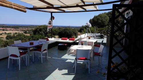 a patio with white tables and chairs and a view at Villa delle torri in Pula