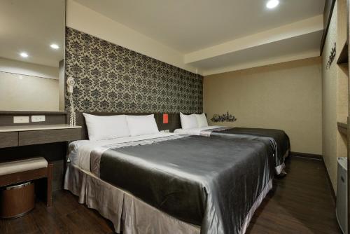 a hotel room with a large bed and a desk at Happy Hotel in Kaohsiung