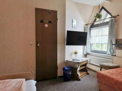 a room with a door and a desk with a television at Elisabeth Stube in Neuss