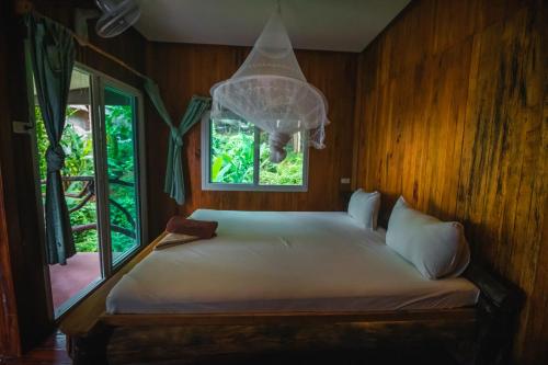 - une chambre avec un grand lit et une fenêtre dans l'établissement Phi Phi Sunset Bay Resort, sur les Îles Phi Phi
