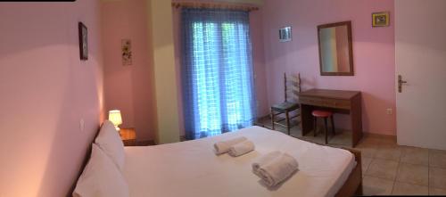 a bedroom with a white bed with towels on it at Villa Swan in Lefkada
