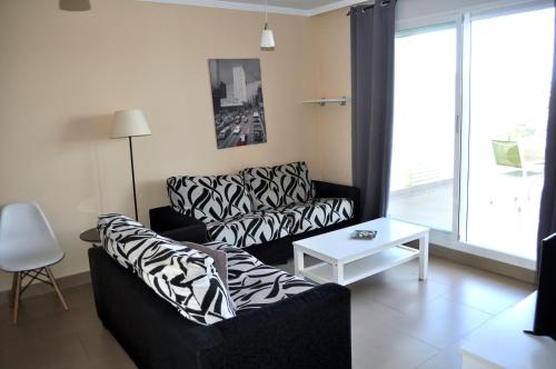 sala de estar con sofá y mesa en Brisas C8, ático, 3 dormitorios, playa a 50m, by Bookindenia, en Denia