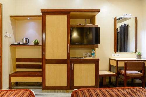 a room with a bed and a tv in a room at Hotel Ameya in Mumbai