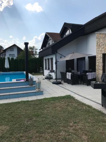 a backyard with a swimming pool and a house at Luxeriöse Villa mit Bergblick in Donji Ljenobud