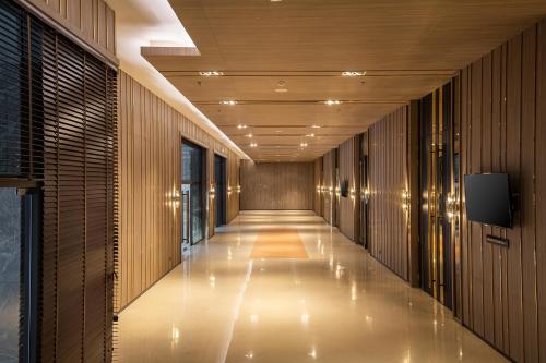 a corridor of a building with wooden walls and a long hallway at The Heritage Chiang Rai Hotel and Convention in Chiang Rai