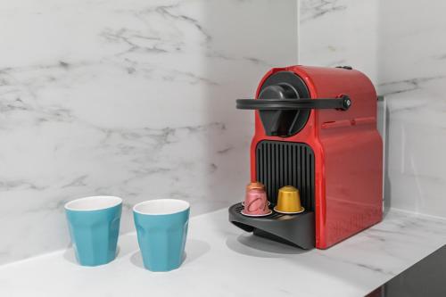 un grille-pain rouge à côté de deux tasses sur un comptoir dans l'établissement WS Marais - Musée Pompidou, à Paris