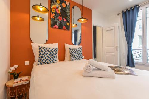 a bedroom with a large bed with orange walls at Apartments WS Marais - Musée Pompidou in Paris
