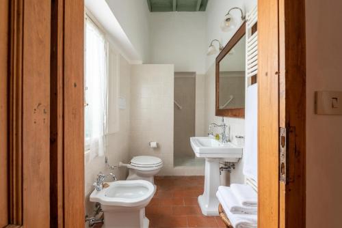 a bathroom with two toilets and a sink and a mirror at Castello Di Meleto in Gaiole in Chianti