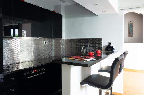 uma cozinha com armários pretos e um balcão preto em The Burton Luxury 1BR in Plaka, Athens em Atenas