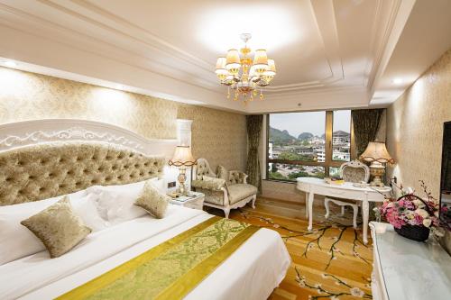 Un dormitorio con una cama grande y una lámpara de araña. en Guilin Bravo Hotel-The Grand Wing, en Guilin