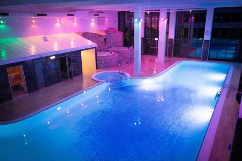 a large swimming pool in a room with a bar at Village Hotel Wirral in Bromborough