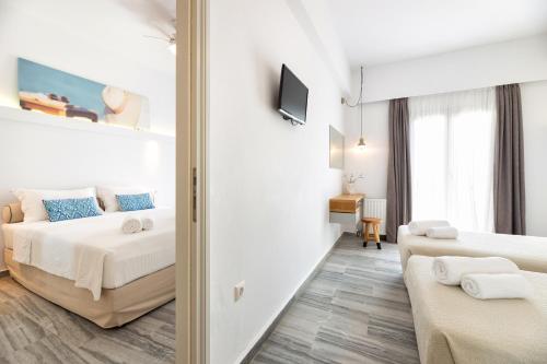 a bedroom with two beds and a living room at Golden Beach Hotel in Chrissi Akti