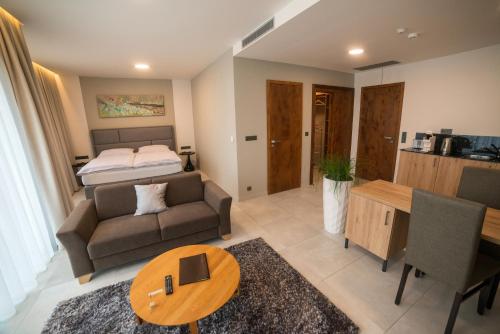 MG Restaurace/Luxury Apartments في ملادا بوليسلاف: غرفة معيشة مع أريكة وسرير