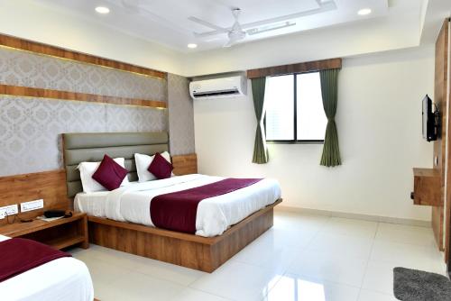 a hotel room with two beds and a window at Hotel Royal King by Sky Stays in Ahmedabad