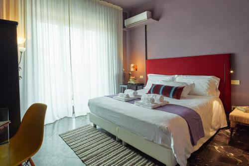 1 dormitorio con 1 cama grande y cabecero rojo en La Terrazza, en Arezzo