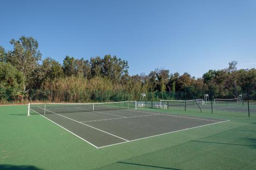 a tennis court with two tennis nets on it at DS One Vacances, Prairies de la Mer in Grimaud