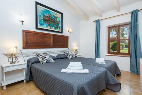 a bedroom with a bed and a painting on the wall at VILLA CAN RITO in Felanitx