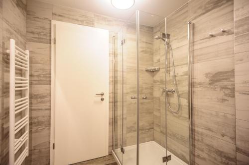 a shower with a glass door in a bathroom at Apartments Villa Tatiana in Bled