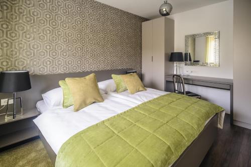 a bedroom with a large bed with a green blanket at Apartments Villa Tatiana in Bled