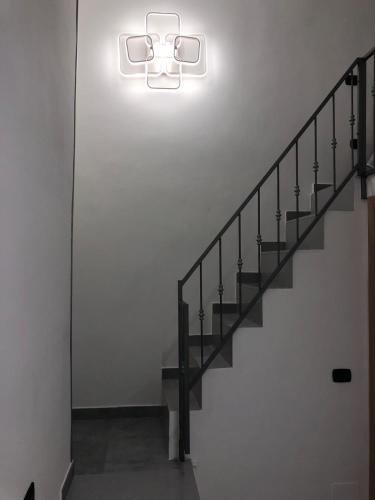 una scala con una luce sul muro di Casa pallonetto a Napoli