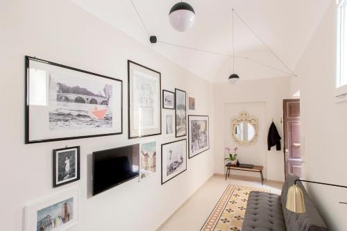 een woonkamer met een tv aan een muur met foto's bij Casa di Artemisia in Rome
