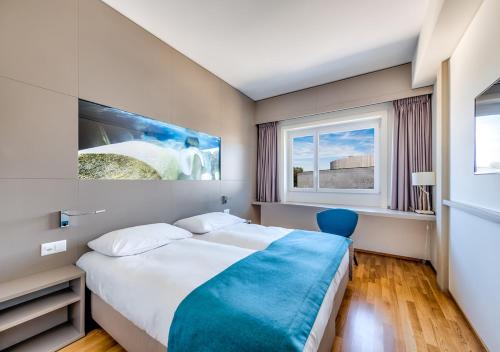 Un pat sau paturi într-o cameră la Aquatis Hotel