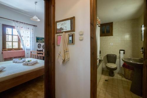 a bedroom with a bed and a bathroom with a sink at Traditional Family Cretan Home! in Yerakianá