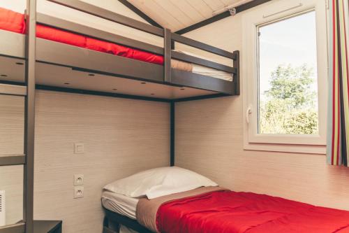 een slaapkamer met een stapelbed in een kamer bij Terres de France - Les Hameaux de Pomette in Marminiac