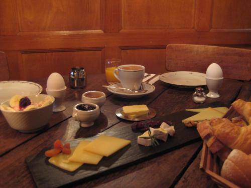a wooden table with cheese and eggs on it at Hotel Restaurant Schwert Thun in Thun
